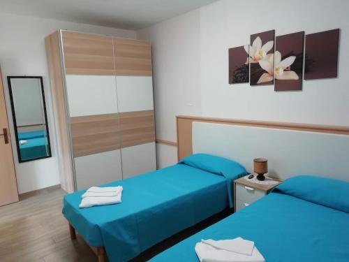 Habitación de hotel con 2 camas y espejo en Appartamento "Laghet" a piano terra con giardino, en Coredo