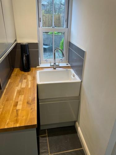 a kitchen with a sink and a window at The House on the Common in Coity