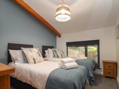 a bedroom with two beds and a chandelier at Tolcarne in Truro