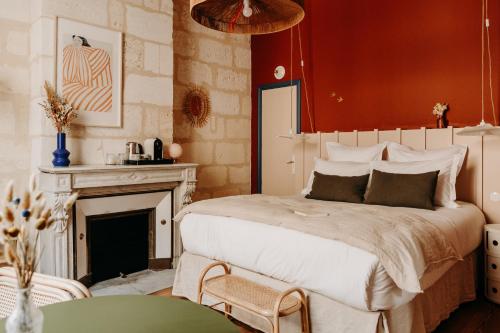 1 dormitorio con 1 cama grande y chimenea en B&B Maison Rosa en Burdeos