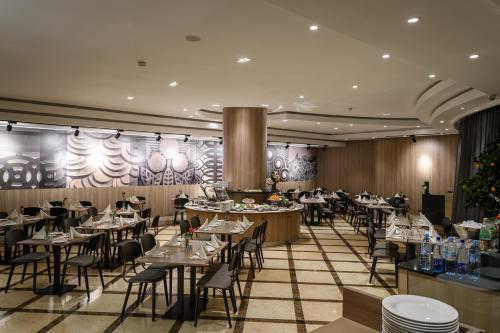 a restaurant with tables and chairs in a room at Idou Anfa Hôtel & Spa in Casablanca