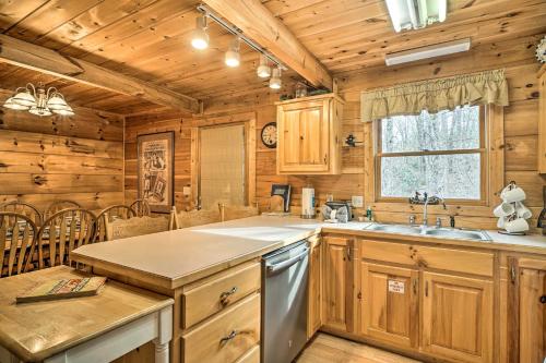 uma cozinha com armários de madeira, um lavatório e um fogão em Wandering Bear Cabin with Game Room and Hot Tub! em Sevierville