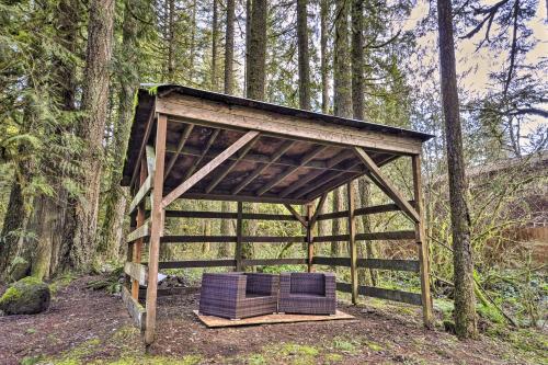 a wooden shelter with two chairs in the woods at Walk to Zigzag River The Sundance Cottage in Rhododendron