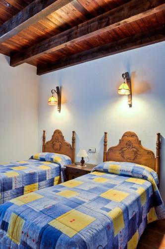 a bedroom with two beds with blue and yellow sheets at Casa Huerta San Francisco in Casarabonela