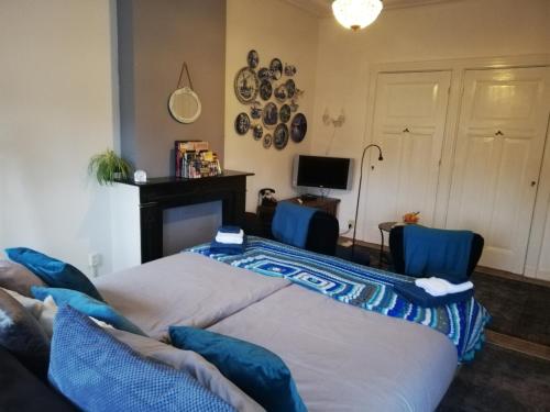een slaapkamer met 2 bedden en 2 blauwe stoelen bij Bed and Breakfast Raapop in Arnhem