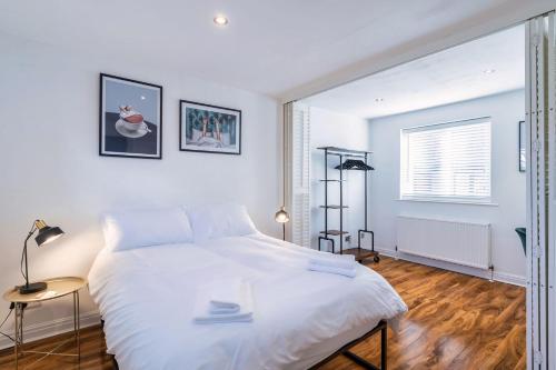 a white bedroom with a large bed and a window at Charming & Central House with Garden and Free Parking in Beverley