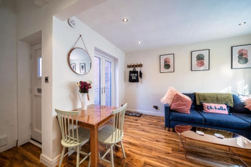 a living room with a table and a blue couch at Charming & Central House with Garden and Free Parking in Beverley