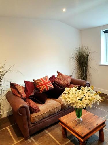 a living room with a couch with pillows and a table at The Priory in Scorton