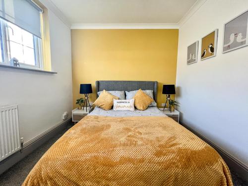 sypialnia z dużym łóżkiem z żółtymi ścianami w obiekcie The Old Lost Shepherd w mieście Cleethorpes