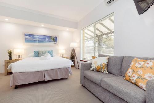 a living room with a bed and a couch at A2 Spacious Apartment with WiFi Kitchenette in Perth