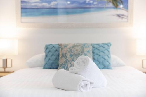 a white bed with towels on top of it at A2 Spacious Apartment with WiFi Kitchenette in Perth