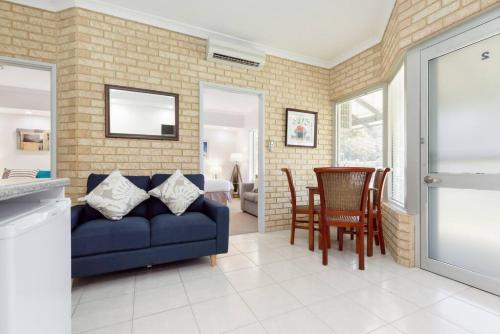 a living room with a blue couch and a table at A2 Spacious Apartment with WiFi Kitchenette in Perth