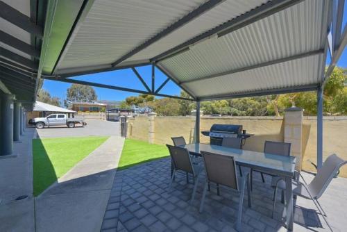 a patio with a table and chairs and a grill at A2 Spacious Apartment with WiFi Kitchenette in Perth