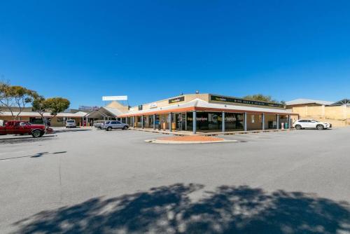 a parking lot with a building in a parking lot at A2 Spacious Apartment with WiFi Kitchenette in Perth