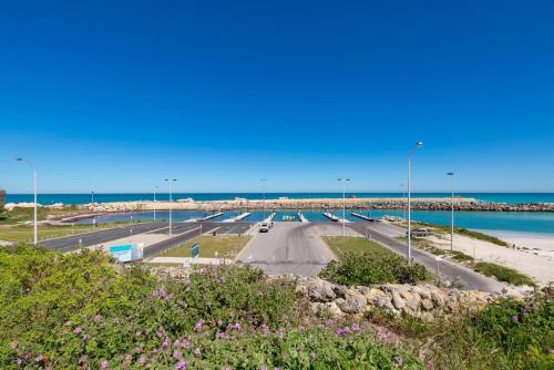 a road next to the beach with cars on it at A2 Spacious Apartment with WiFi Kitchenette in Perth