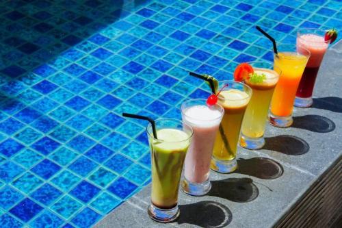 マカッサルにあるFavor Hotel Makassar City Center By LIFEのプールの横に並んだ飲み物