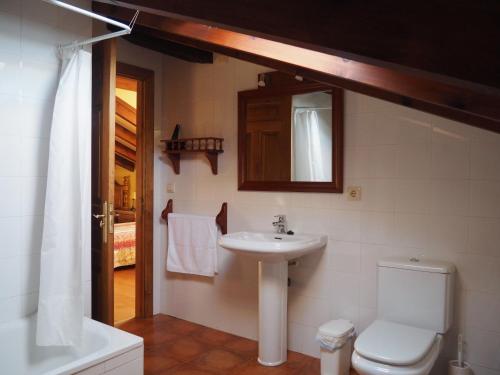 y baño con lavabo, aseo y espejo. en Casa Rural La Roza 2, en Buelles