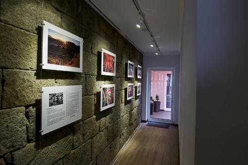 un couloir avec un mur en briques et des photos. dans l'établissement Memória Boutique Hostel, à Angra do Heroísmo