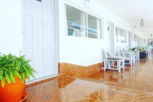 a hallway with a white door and plants and chairs at Hotel Ivania´s in Masaya