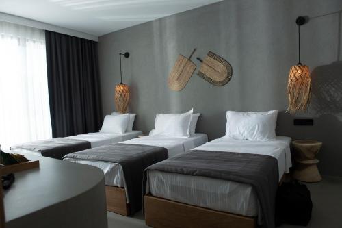 a hotel room with three beds in a room at Regia Mare Beach Hotel & Spa Bodrum in Ortakent