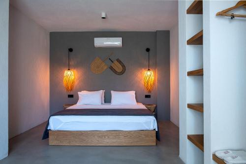 a bedroom with a bed and two lights on the wall at Regia Mare Beach Hotel & Spa Bodrum in Ortakent
