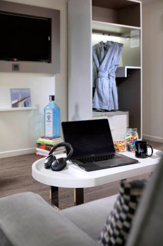 a laptop on a white table in a living room at INNSiDE by Meliá New York Nomad in New York