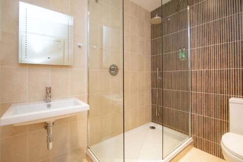 a bathroom with a shower and a sink and a toilet at Royal Golf Hotel in Dornoch
