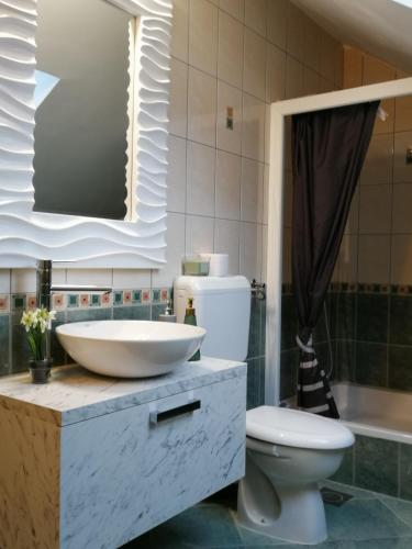a bathroom with a sink and a toilet and a tub at Apartmani Sunset in Slavonski Brod