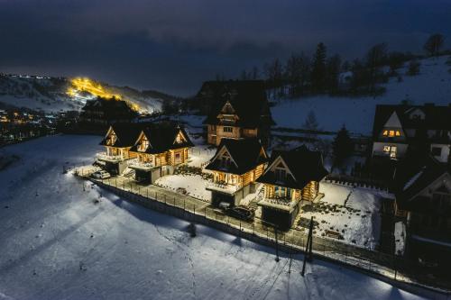 a group of houses in the snow at night at Osada Bachledzki Wierch Odkryj Zakopane in Zakopane