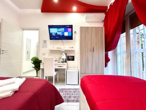 een slaapkamer met een rood bed en een bureau bij Terrazza Garibaldi in Napels