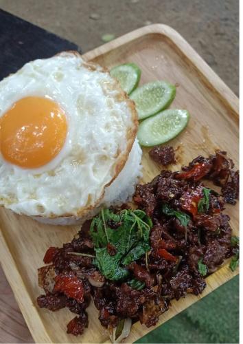 a plate of food with a fried egg and some pickles at Do Dee cafe in Bangkok