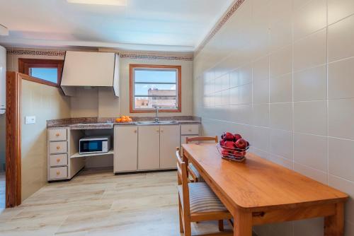 a kitchen with a wooden table with a bowl of fruit on it at Apartamento Bressol 3ºd in Port de Pollensa