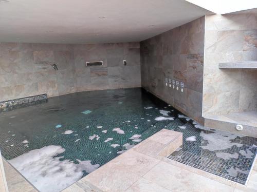 - une grande piscine d'eau dans une chambre avec des rochers dans l'établissement Oasis Beach X 106, à Guardamar del Segura