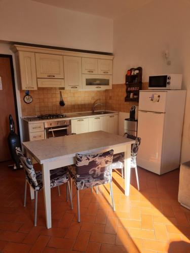 a kitchen with a table and a white refrigerator at Casa Mille Baci con Parcheggio in Livorno