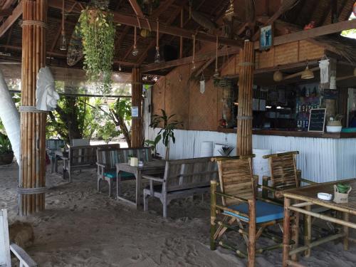 
a patio area with chairs, tables and umbrellas at Coco Sunset Beach in Ban Bang Po
