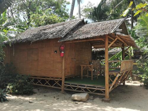 a small wooden hut with a grass roof at Coco Sunset Beach in Ban Bang Po