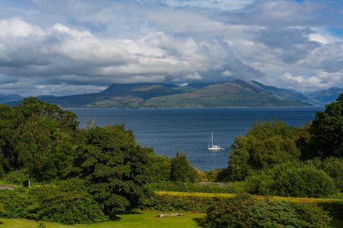 a boat in the water with mountains in the background at Duisdale House Hotel in Isleornsay