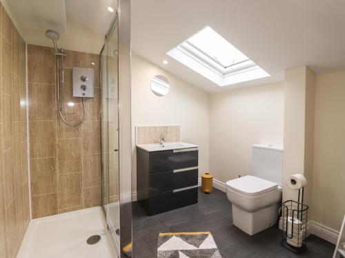 a bathroom with a shower and a toilet and a sink at The Studio - Charonini in Penrith