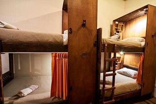 a room with three bunk beds and a ladder at The Secret Garden in Quito