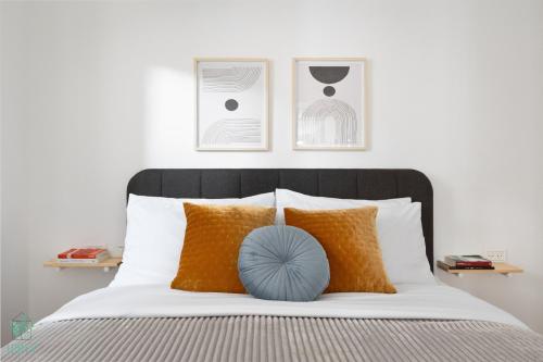 sypialnia z łóżkiem z pomarańczowymi i białymi poduszkami w obiekcie Mate ALMA - By HOMY w Jerozolimie