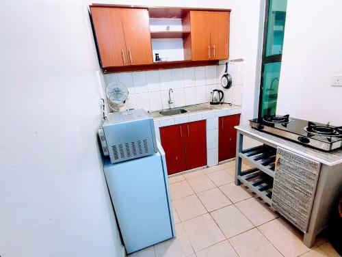 uma pequena cozinha com frigorífico e micro-ondas em ASHÉ em Naivasha