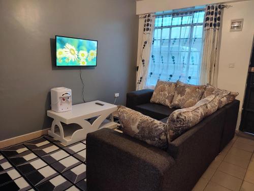 ASHÉ في نيفاشا: غرفة معيشة مع أريكة وطاولة