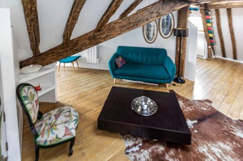 un salon avec un canapé bleu et une table dans l'établissement Spacious Apartment Near The Palais Garnier, à Paris