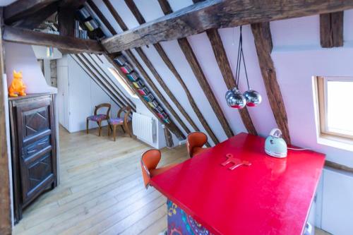 Cette chambre revêtue de parquet comprend une table et des chaises rouges. dans l'établissement Spacious Apartment Near The Palais Garnier, à Paris
