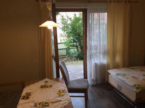 ein Schlafzimmer mit einem Tisch, einem Bett und einem Fenster in der Unterkunft Appartements Gillmeier Herta in Bad Griesbach