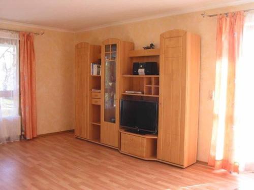 a living room with a tv and wooden shelves at Appartements Gillmeier Herta in Bad Griesbach