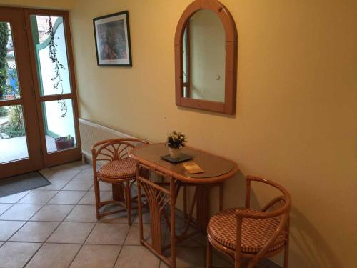 a table and chairs in a room with a mirror at Appartements Gillmeier Herta in Bad Griesbach