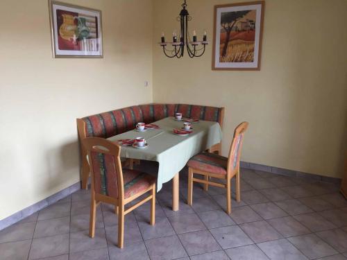 a dining room table with chairs and a white table cloth at Appartements Gillmeier Herta in Bad Griesbach