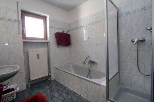 a bathroom with a bath tub and a sink at Appartements Gillmeier Herta in Bad Griesbach