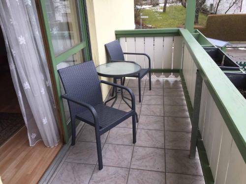 two chairs and a table on a balcony at Appartements Gillmeier Herta in Bad Griesbach